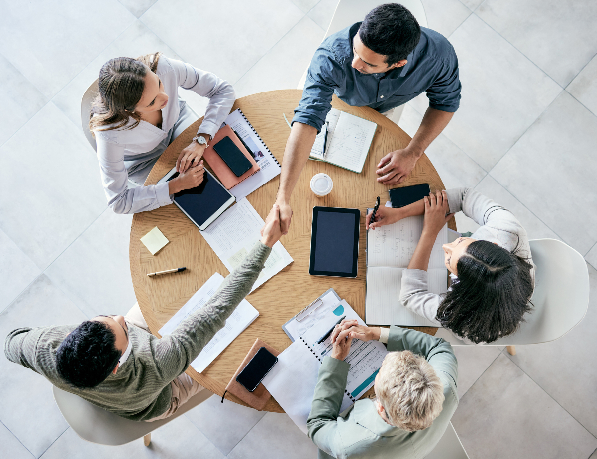 Team of business people shaking hands over a table