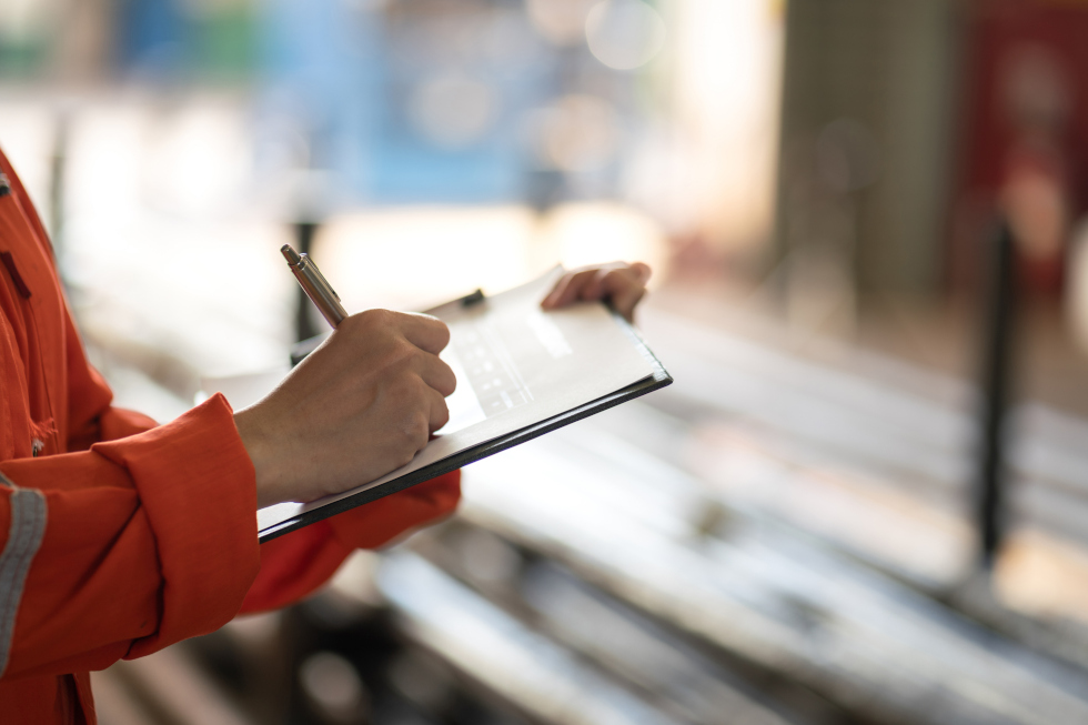 person writing on clipboard
